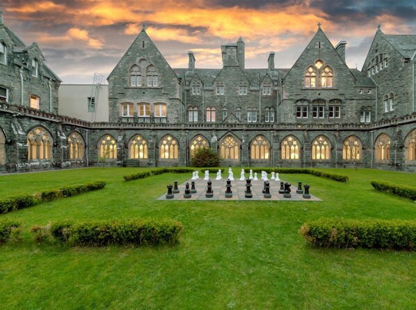 A historic building with a courtyard featuring a chessboard.