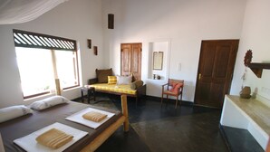 A room with two beds, a wooden bench, a small table, and a chair. - The Danish Villa (Arugam Bay)