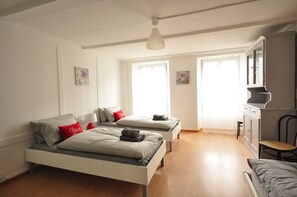 A bedroom with two single beds, a desk, and a chair.