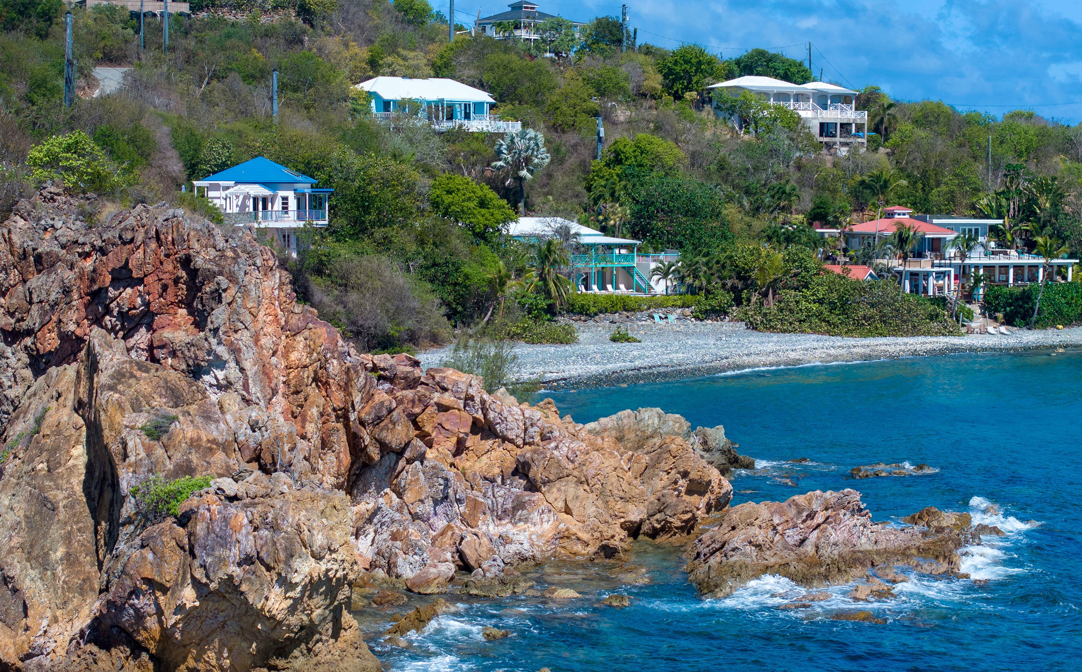 Une propriété située sur la côte, comprenant plusieurs maisons, des falaises rocheuses et offrant une vue dégagée sur l’océan.