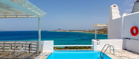 En säsongsöppen utomhuspool, parasoller och solstolar