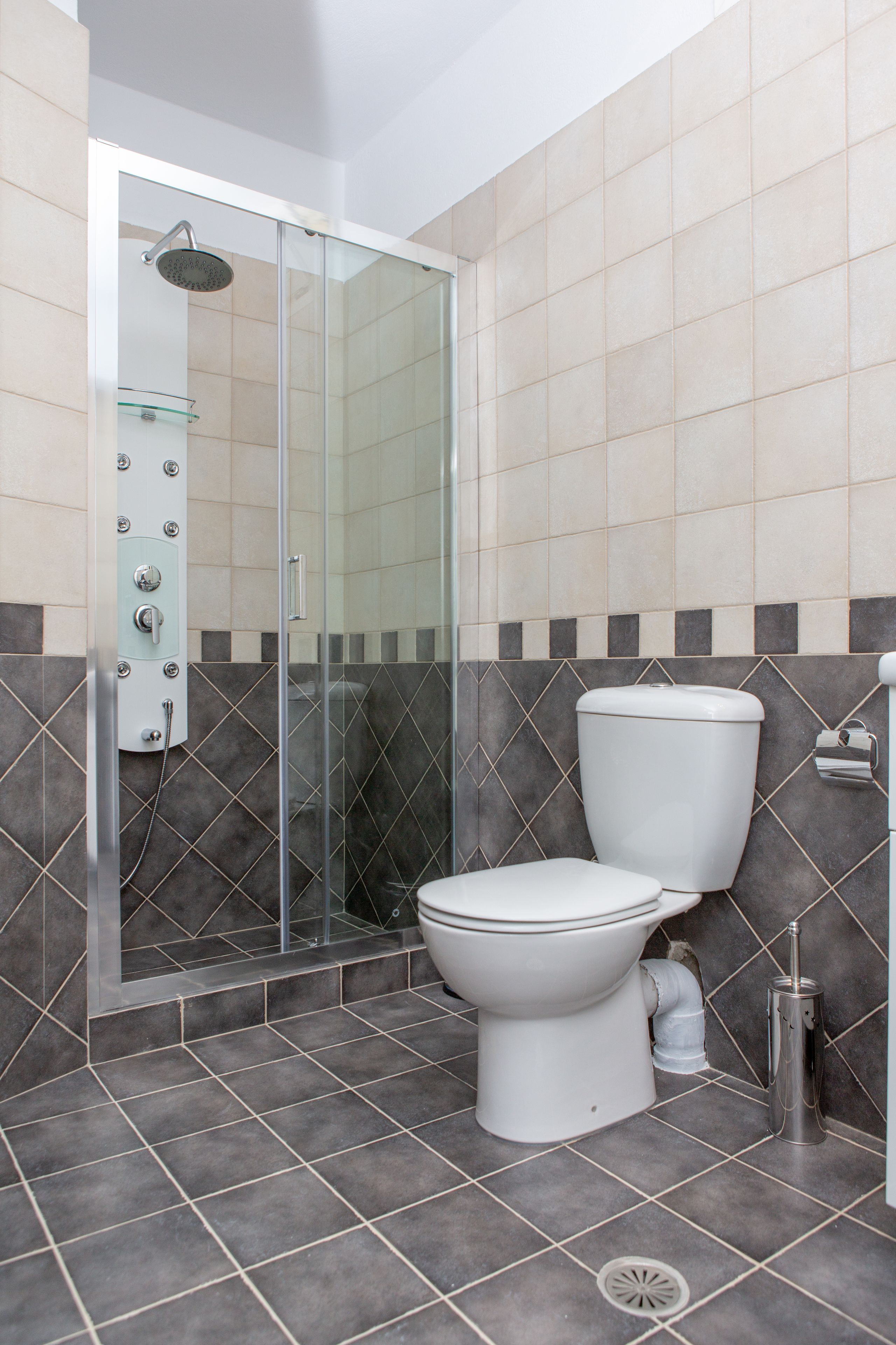 A modern bathroom with a glass-enclosed shower, a toilet, and a bidet.