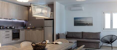 A modern kitchen with wooden cabinets, a dining table with chairs, a sofa, and a chair.