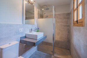 A modern bathroom with a glass-enclosed shower, a white sink, and a mirror above it. - Mastaguera Mallorcan style villa with pool and spectacular views (Pollença)