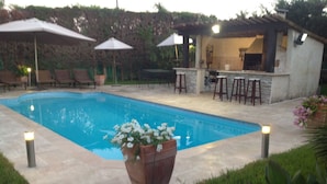 A swimming pool with lounge chairs and umbrellas, a bar area, and a flower planter. - villa near cannes (Mougins)