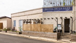 Ein Hotel namens „HOTEL DE LA GARE“ mit einem Schild mit Kontaktdaten und einem Eingang.