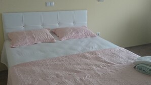 A neatly made bed with a white headboard and pink bedding. - Kumbaz Pansiyon (Sapanca)