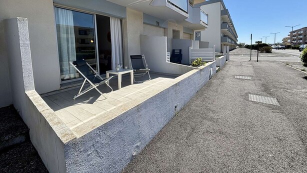 A modern apartment building with balconies, a covered outdoor seating area, and a clear sky. - Cozy 2-Room Apartment, 250m from Beach, Terrace, Private Parking, Sleeps 4 (Port-la-Nouvelle)