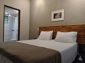 Minibar, tabla de planchar con plancha y ropa de cama