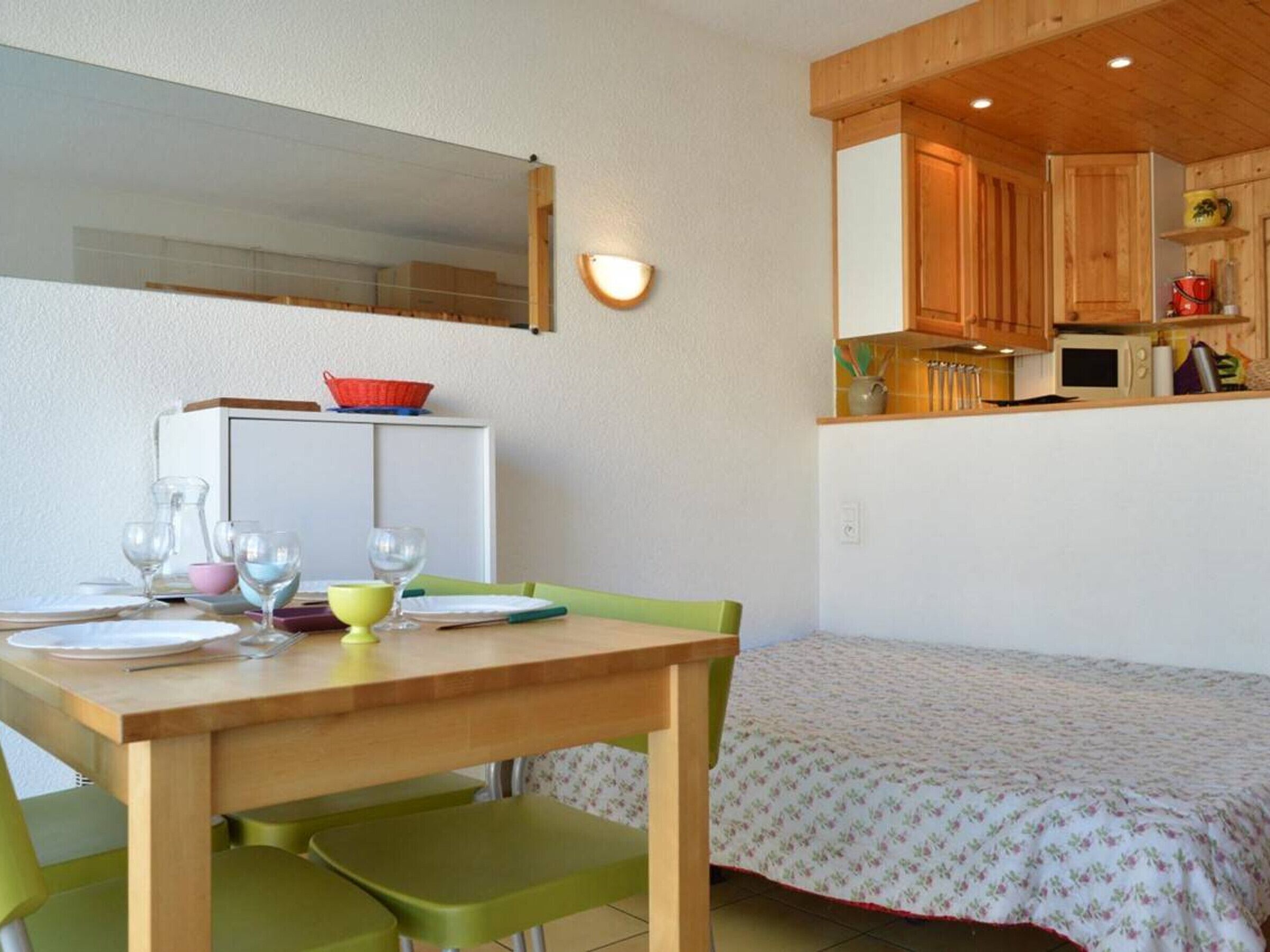 A compact kitchen with wooden cabinets, a microwave, and a small countertop.