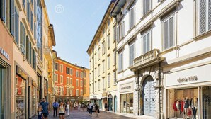 A pedestrian street lined with historic buildings, shops, and a clear sky. - Ciccio B&B (Bergamo)
