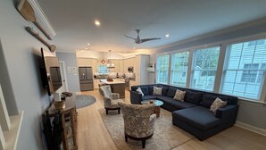 A modern living room with a dark sofa, patterned armchairs, and a coffee table.