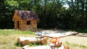 A rustic cabin with a small window and a wooden deck.