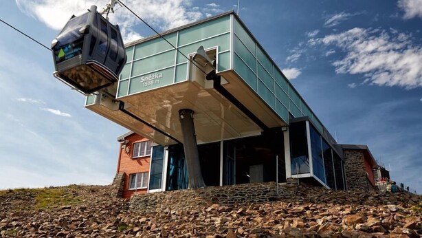 Een modern gebouw met een skilift, een stenen basis en een heldere lucht.