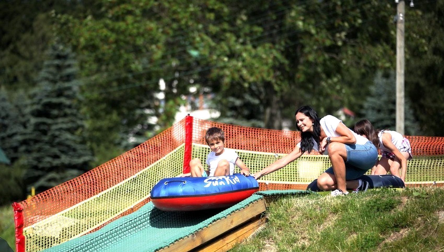 Un parque infantil con un tobogán y una zona vallada.