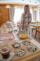 Disposição de buffet com diversos alimentos e acompanhamentos.