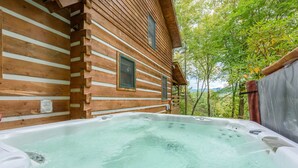 A wooden cabin with a hot tub in front. - Creek-front Cabin on Wooded Acres (Sugar Grove)