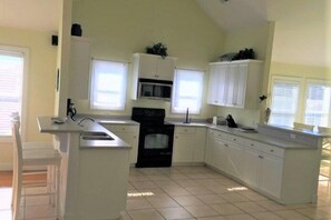 A kitchen with white cabinetry, a central island, and a microwave.