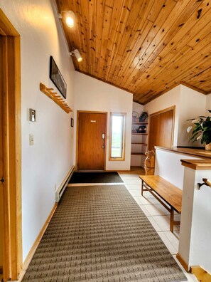 A hallway with wooden ceiling, a bench, a door, and a small window. - Mt CB Home | 3 Bedroom | Hot Tub | Gas Grill | Mt CB View | Second Living Room (Mt. Crested Butte)
