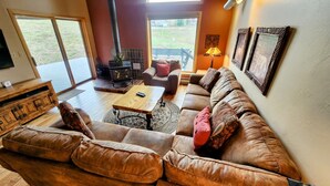 A cozy living room with a large sectional sofa, a wooden coffee table, and a fireplace. - Mt CB Home | 3 Bedroom | Hot Tub | Gas Grill | Mt CB View | Second Living Room (Mt. Crested Butte)