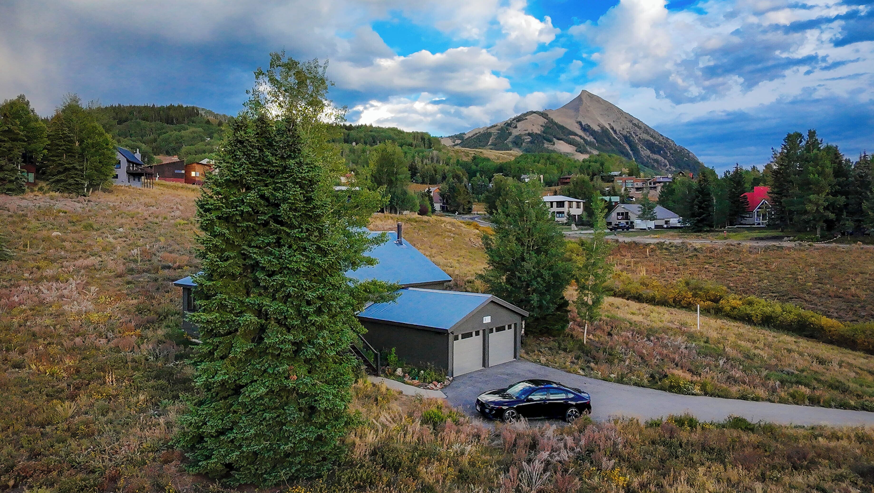 A residential area with houses, a mountain, and a road.