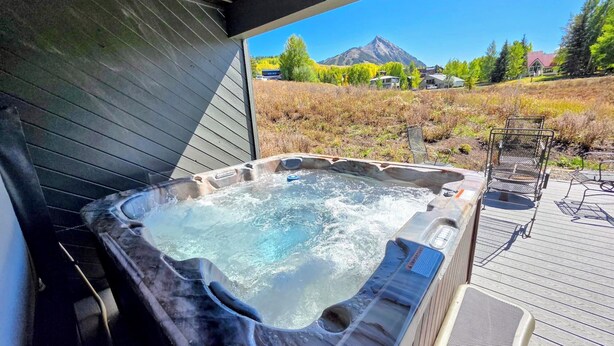 A hot tub with a view of a mountain and houses in the background. - Mt CB Home | 3 Bedroom | Hot Tub | Gas Grill | Mt CB View | Second Living Room (Mt. Crested Butte)