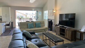 A living room with a leather sofa, a television, and a fireplace. - ☀️PERFECT LOCATION, SPACIOUS and affordable! SOUTH MISSION BEACH Steps to Ocean! (San Diego)