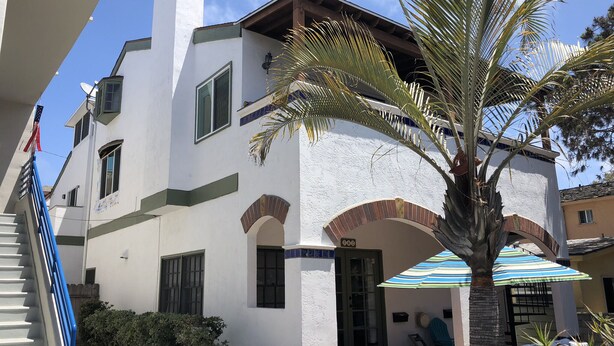 A two-story building with a white exterior, a balcony, and a palm tree. - ☀️PERFECT LOCATION, SPACIOUS and affordable! SOUTH MISSION BEACH Steps to Ocean! (San Diego)