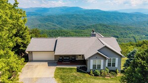 A house with a large front yard, a garage, and a view of mountains. - Best mountain view in TN! See 3 states from the deck! See the houses in valley? (Tallassee)