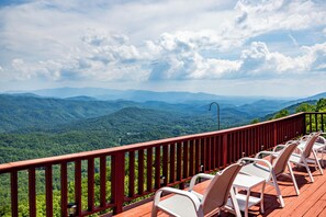 A deck with chairs overlooking a mountainous landscape. - Best mountain view in TN! See 3 states from the deck! See the houses in valley? (Tallassee)