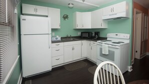 A kitchen with white cabinets, a stove, and a microwave. - Renovated and walking distance to Downtown  (Beaufort)