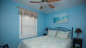 A bedroom with a bed, a ceiling fan, a window with blinds, a nightstand, and a painting on the wall. - Renovated and walking distance to Downtown  (Beaufort)