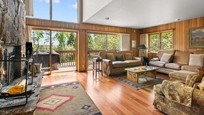 A spacious living room with a fireplace, large windows, and a balcony. - RMR: Wind River 10 Condo in Teton Village (Teton Village)