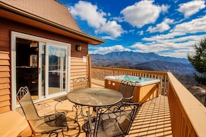 A wooden deck with a hot tub, patio furniture, and a mountain view. - Her Majesty's Way, Awesome Mtn Views, FREE tickets each paid day, Hot TUB, WIFI (Gatlinburg)