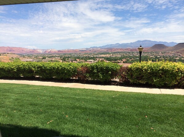 A landscaped area with a view of a town and mountains in the distance.