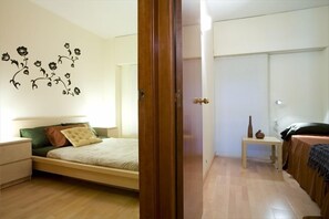 A bedroom with a bed, bedside table, and a wall decoration.
