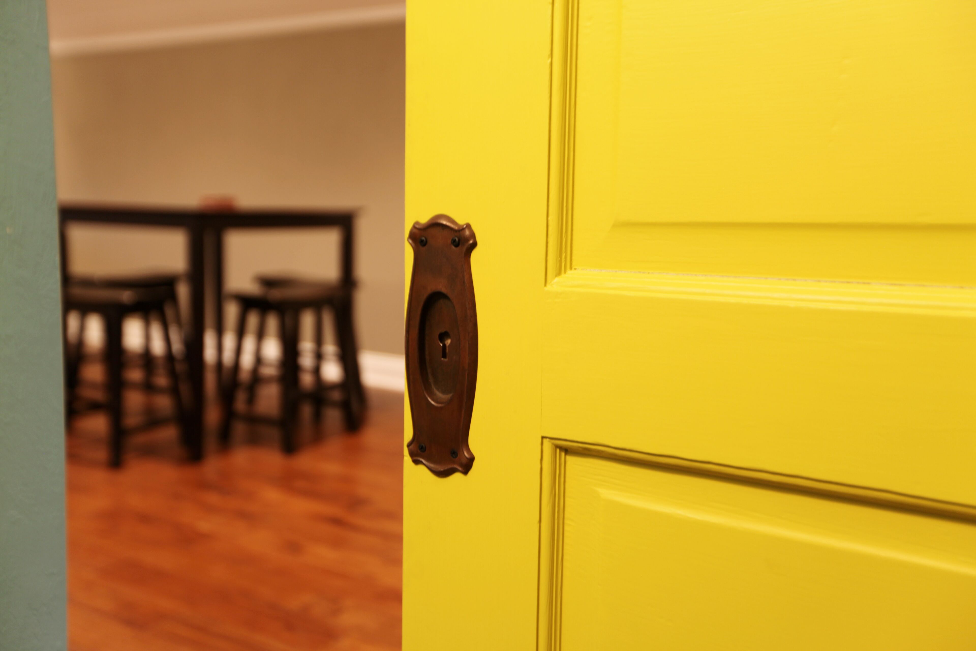 A yellow door with a keyhole and a handle.
