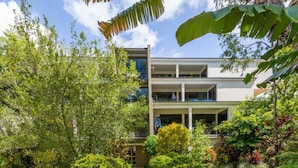 A multi-story building with a garden in front. - Tranquility Chill at Palm Cove (Palm Cove)