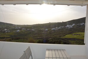 Enjoy the serene view of rolling hills and distant buildings from this balcony.