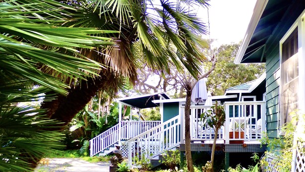 A house with a white porch, a staircase, and a garden with various plants. - Under the Oaks Santa Barbara (Santa Barbara)