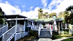 A two-story house with a porch, a staircase leading to the upper floor, and a small garden area. - Under the Oaks Santa Barbara (Santa Barbara)