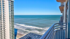 Ein Hochhaus mit Balkon und Blick auf einen Strand.