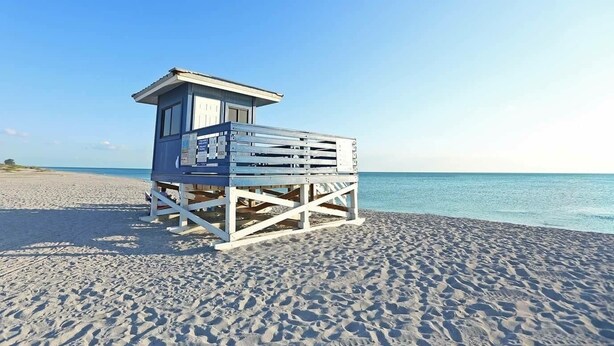 A lifeguard tower on a sandy beach with clear blue water. - Walk to the #1 Beach in America, Offers Heated community Pool, Free Wi-Fi (Siesta Key)