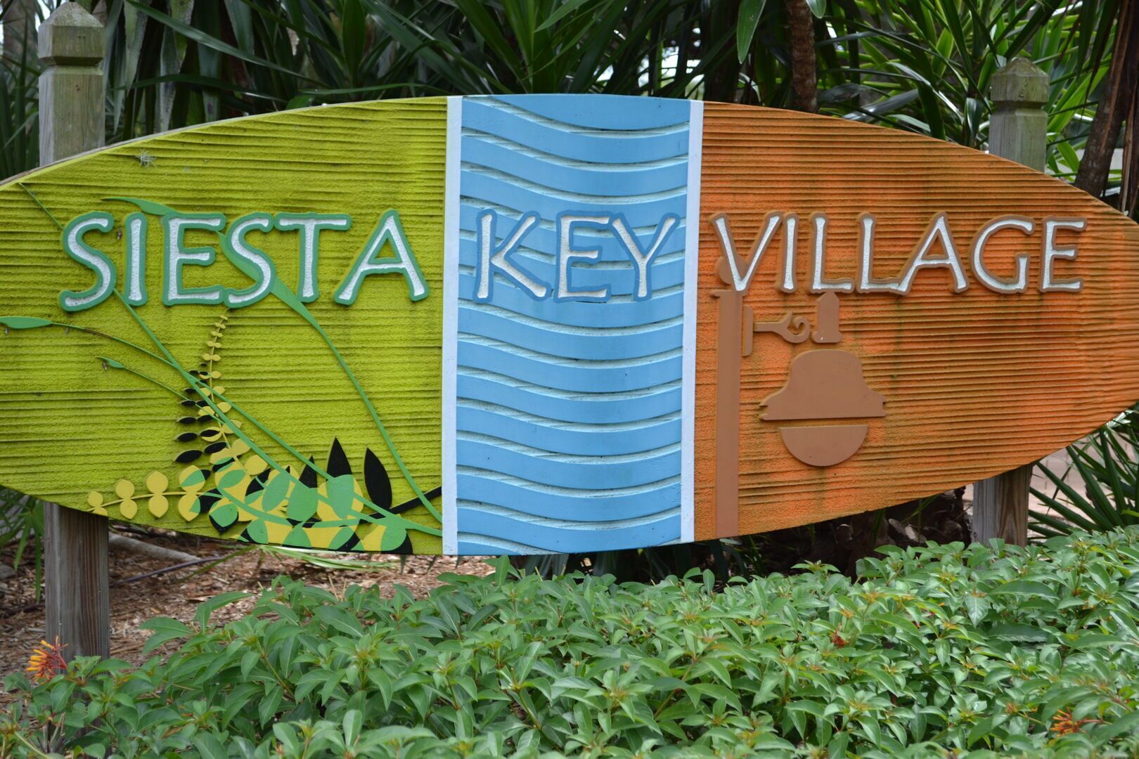 Ein Schild mit der Aufschrift 'SIESTA KEY VILLAGE' und einer stilisierten Darstellung eines Schlüssels.