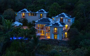 A multi-story house with solar panels, a swimming pool, and a lush garden. - Reefside Villa: Full AC! Pool! Private sandy beach! (St John)