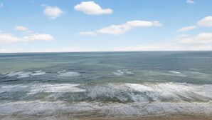 Ein Strand mit blauem Himmel und sanften Wellen.
