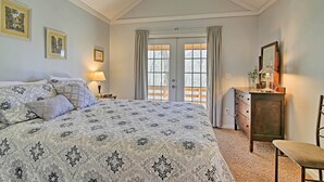 A bedroom with a large bed, a dresser, a chair, and a ceiling fan. - Forest Views! ‘The Woodshop’ Robbinsville Cabin (Robbinsville)