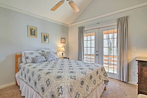 Een slaapkamer met een bed, een nachtkastje, een lamp en een raam met gordijnen.