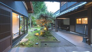 A traditional Japanese-style courtyard with a koi pond, stone lanterns, and a well-maintained garden. - Machiya Hotel Oyado Baison (Mino)