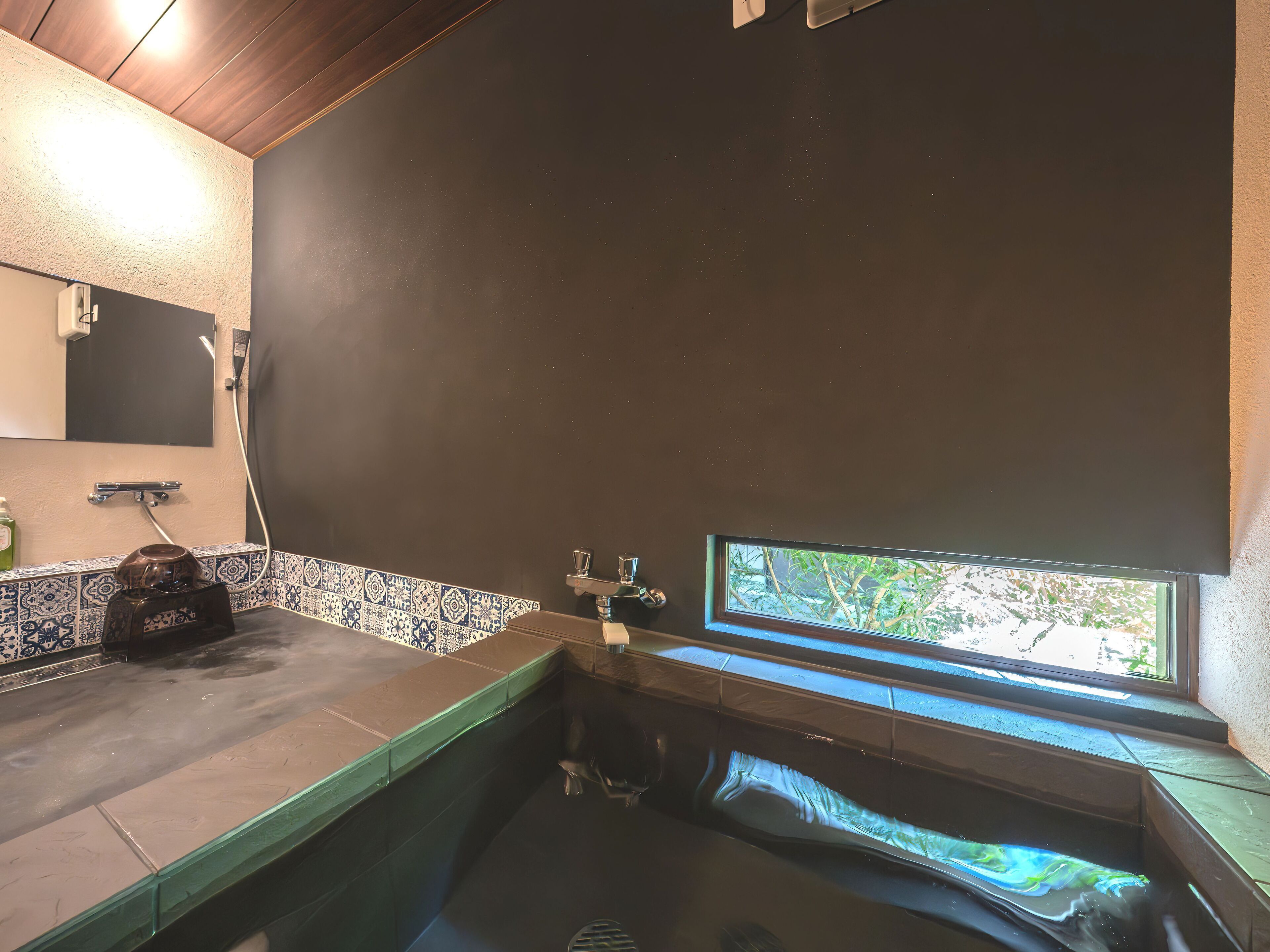 Un baño con bañera, ventana y espejo.